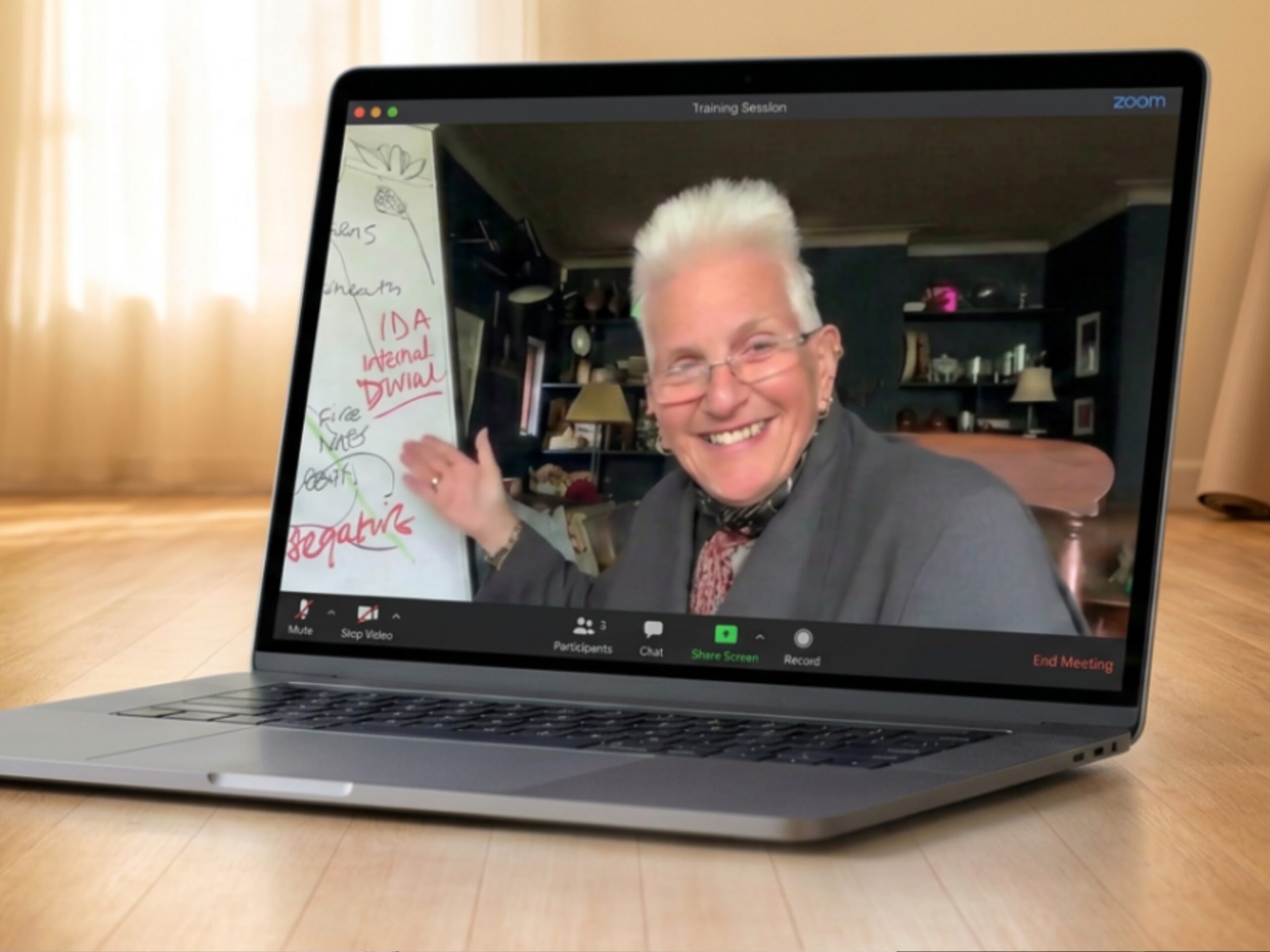 Carolyn Cowan teaching Kundalini Global Teacher Training online from her home, with a whiteboard beside her.